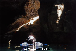 Cave diver surfacing in the cavern section of a flooded m... by Michael Grebler 